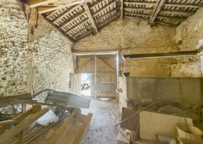 Annonces immobilières à Biard 86580 grange garage à transformer augustins – intérieur de la grange avec charpente apparente murs en pierre et grande porte bois – agence immobilière – Buxerolles 86180